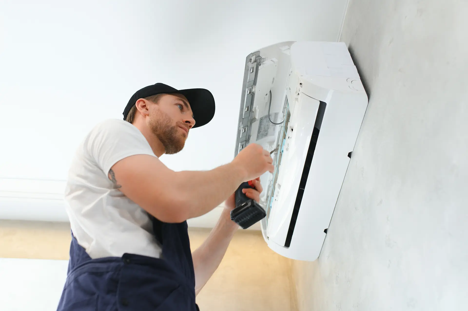 Service man cleaning and performing maintenance on an air conditioning system